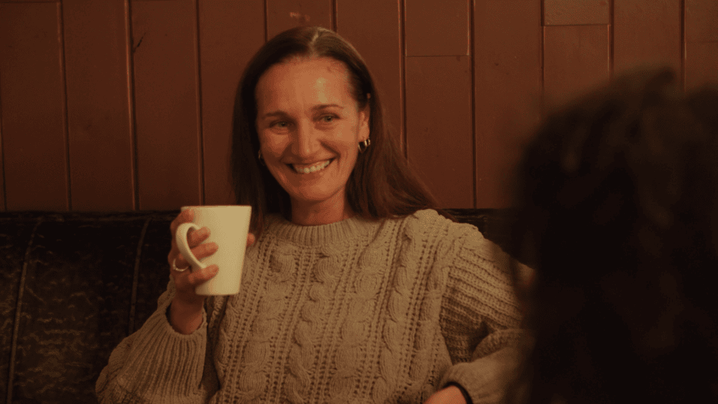 Warm welcoming woman enjoying coffee in cozy café setting. Video Emotion.