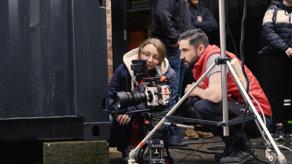 Behind-the-scenes film crew operating camera equipment on location for documentary shoot.
