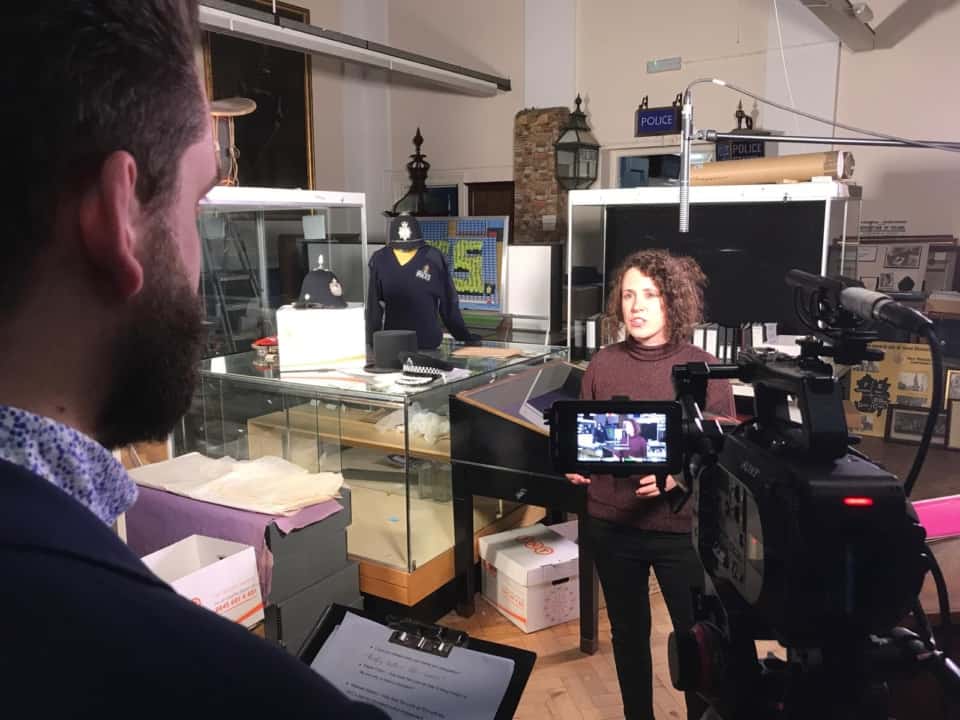 Police-themed documentary filming in a studio, capturing interviews and footage for a film division project.