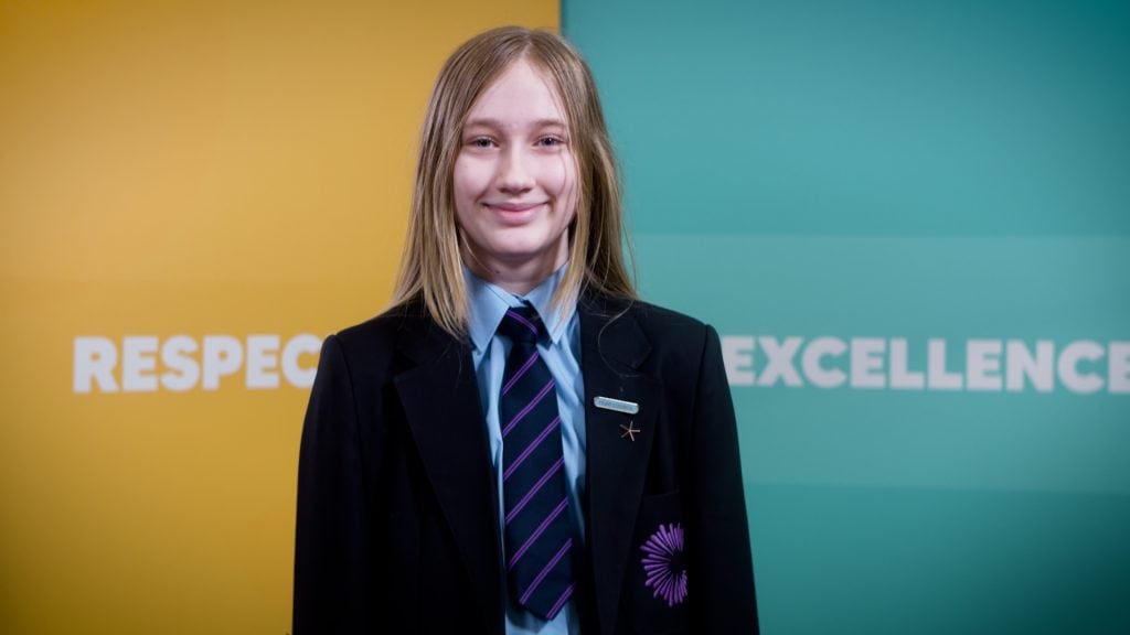 Smiling girl in school uniform, showcasing Film Division video production and educational content.