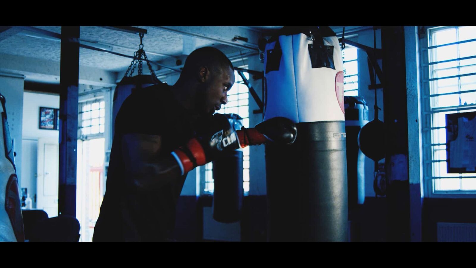 Knockout boxer training with a punching bag at a boxing gym in London.