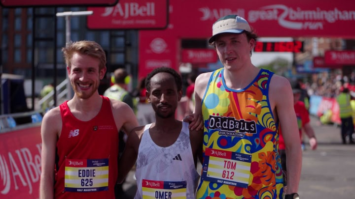 Vibrant marathon runners celebrating after race victory at Birmingham event.
