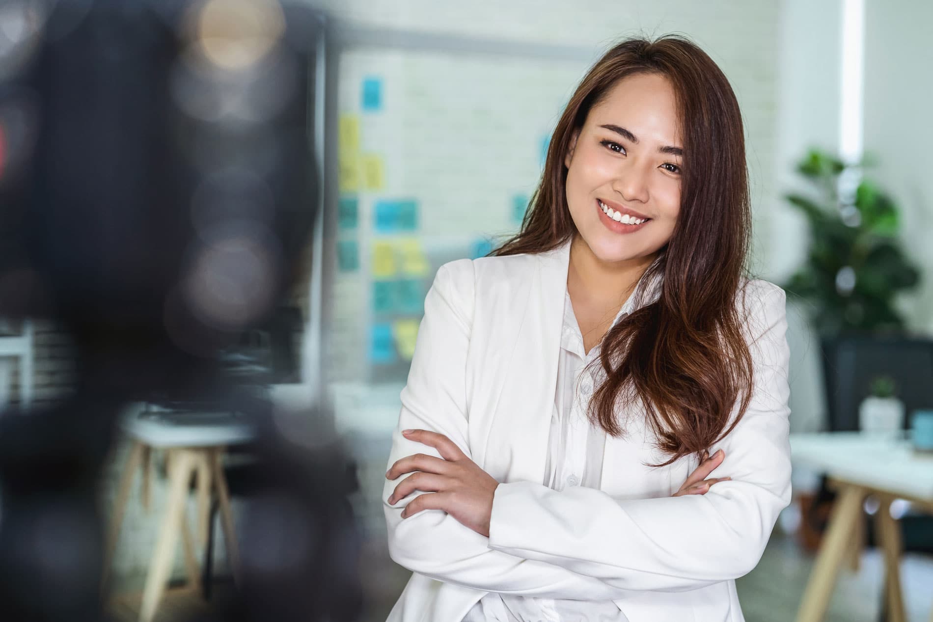 Confident businesswoman smiling in modern office environment.