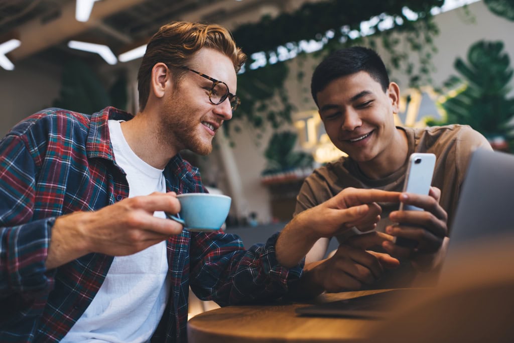 Two marketing executives look at video marketing statistics over coffee