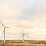 Wind turbines in a renewable energy wind farm at sunset, promoting clean energy solutions.