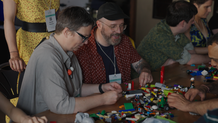 LEGO building activity at film industry event with diverse group enjoying creative teamwork.