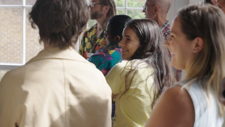Diverse group of people attending a film division event, engaging in a creative and collaborative atmosphere.