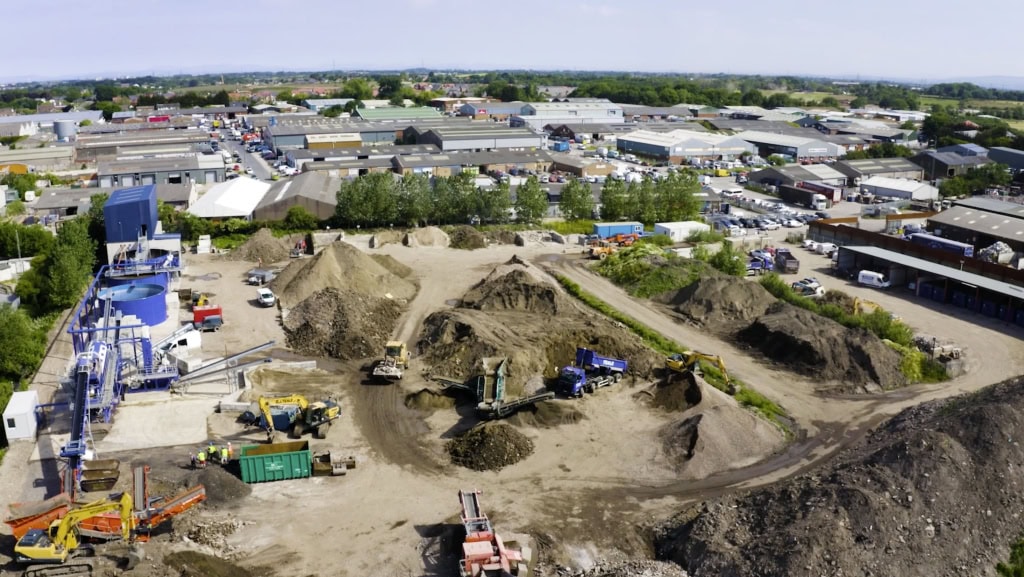 Excavation site with construction machinery in a commercial industrial area. ESG Video.