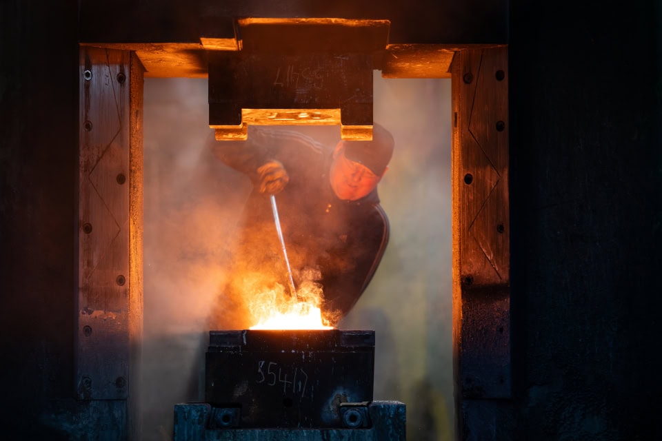 Molten metal being poured in a foundry during metalworking process. Manufacturing video production