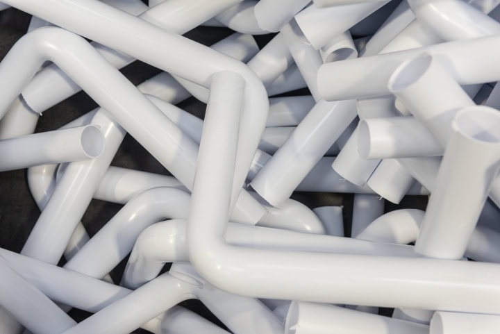 White plastic pipes tangled together, close-up shot.