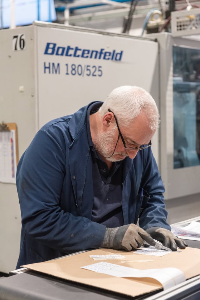 Skilled technician inspecting materials in a manufacturing facility. Manufacturing video production