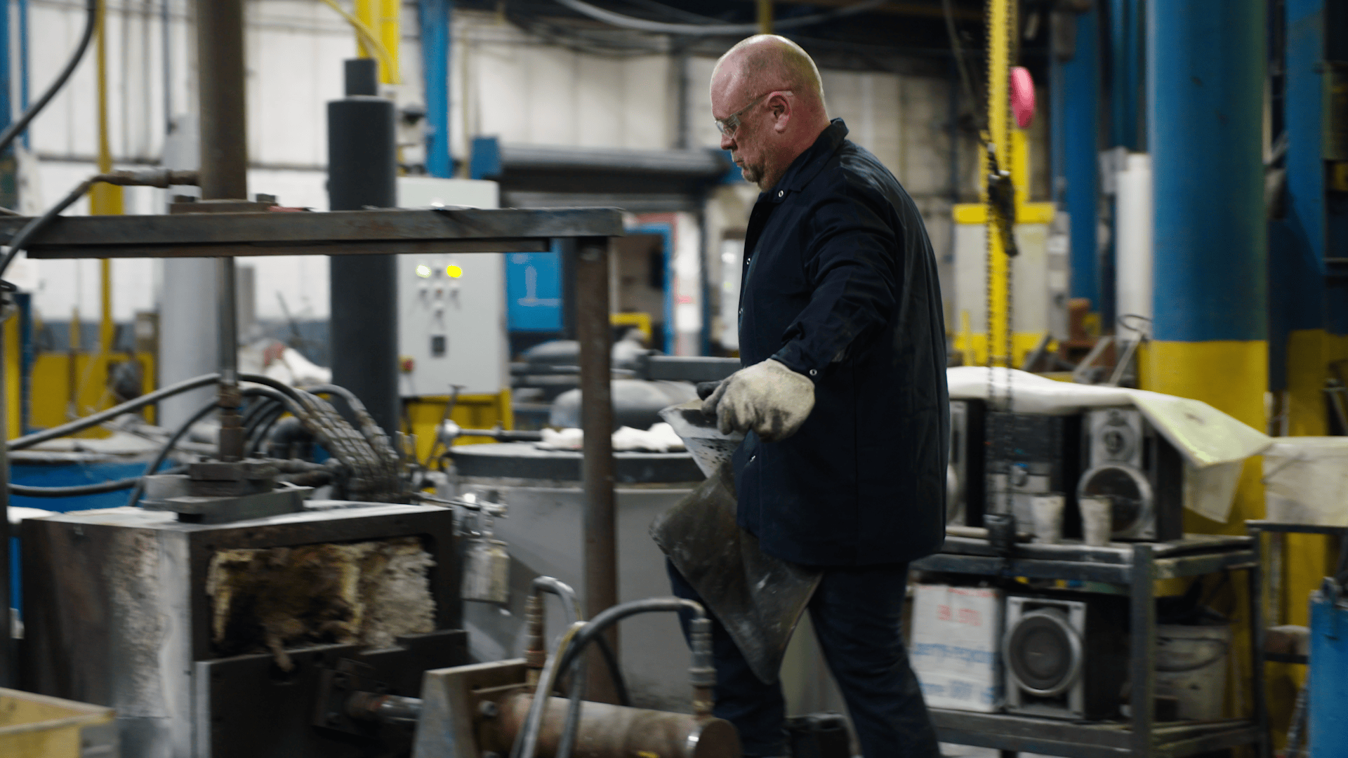 Worker operating machinery in a factory supporting Net Zero strategy.