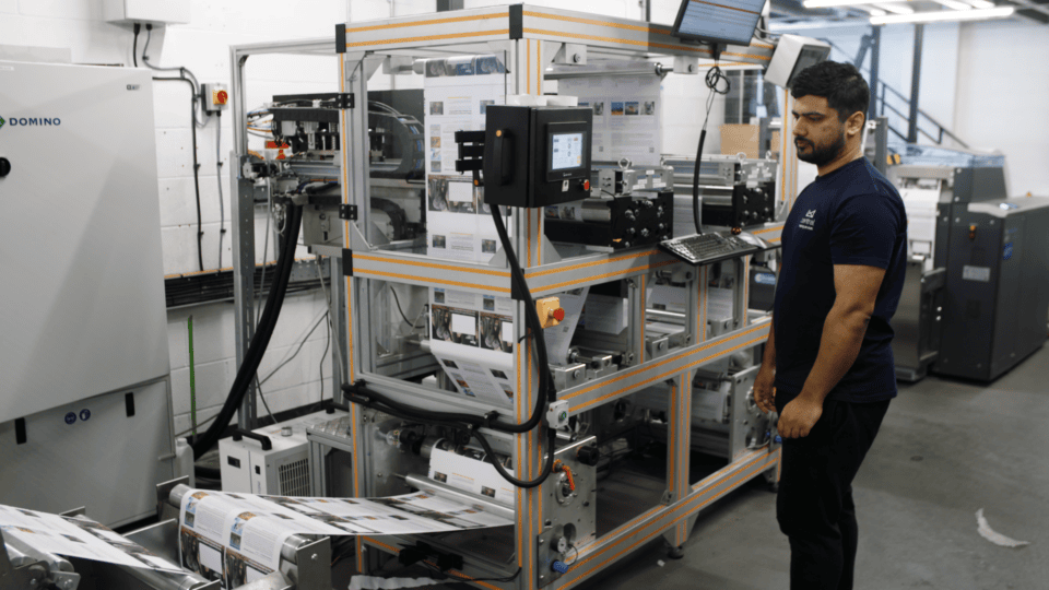 Technician operating eco-friendly machinery in a sustainable film production facility.