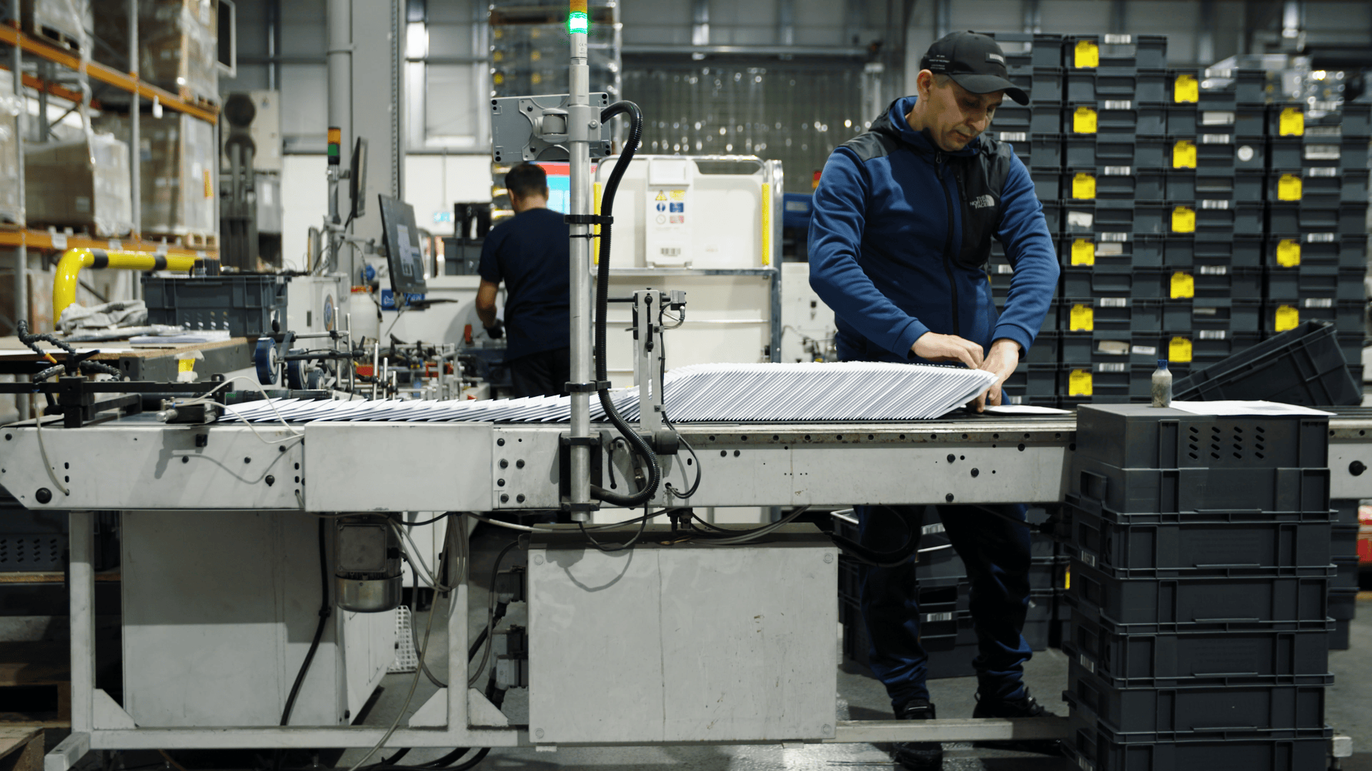 Workers in a factory assembling eco-friendly products for Net Zero goals.