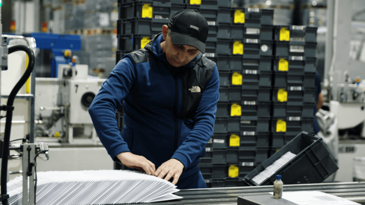 Worker inspecting materials in a sustainable production environment.