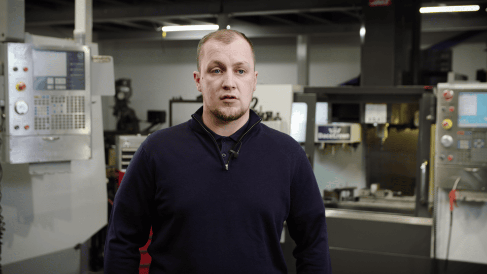 Man in factory with machinery promoting sustainability efforts.