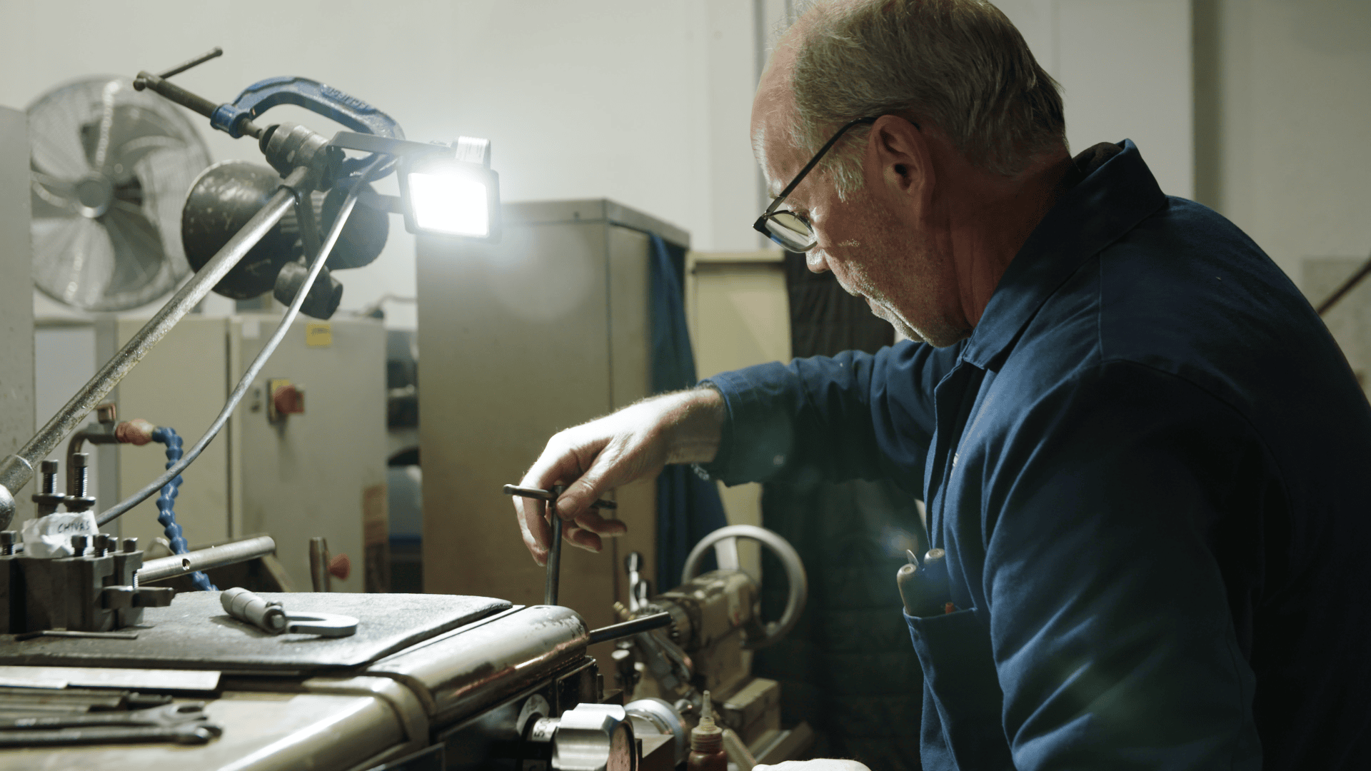 Man working on eco-friendly manufacturing equipment in a workshop.