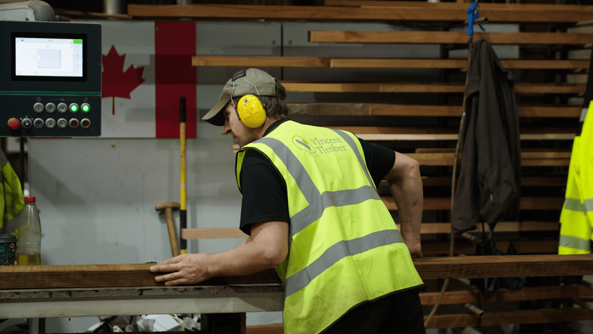 Worker in safety vest operating machinery for sustainable production.