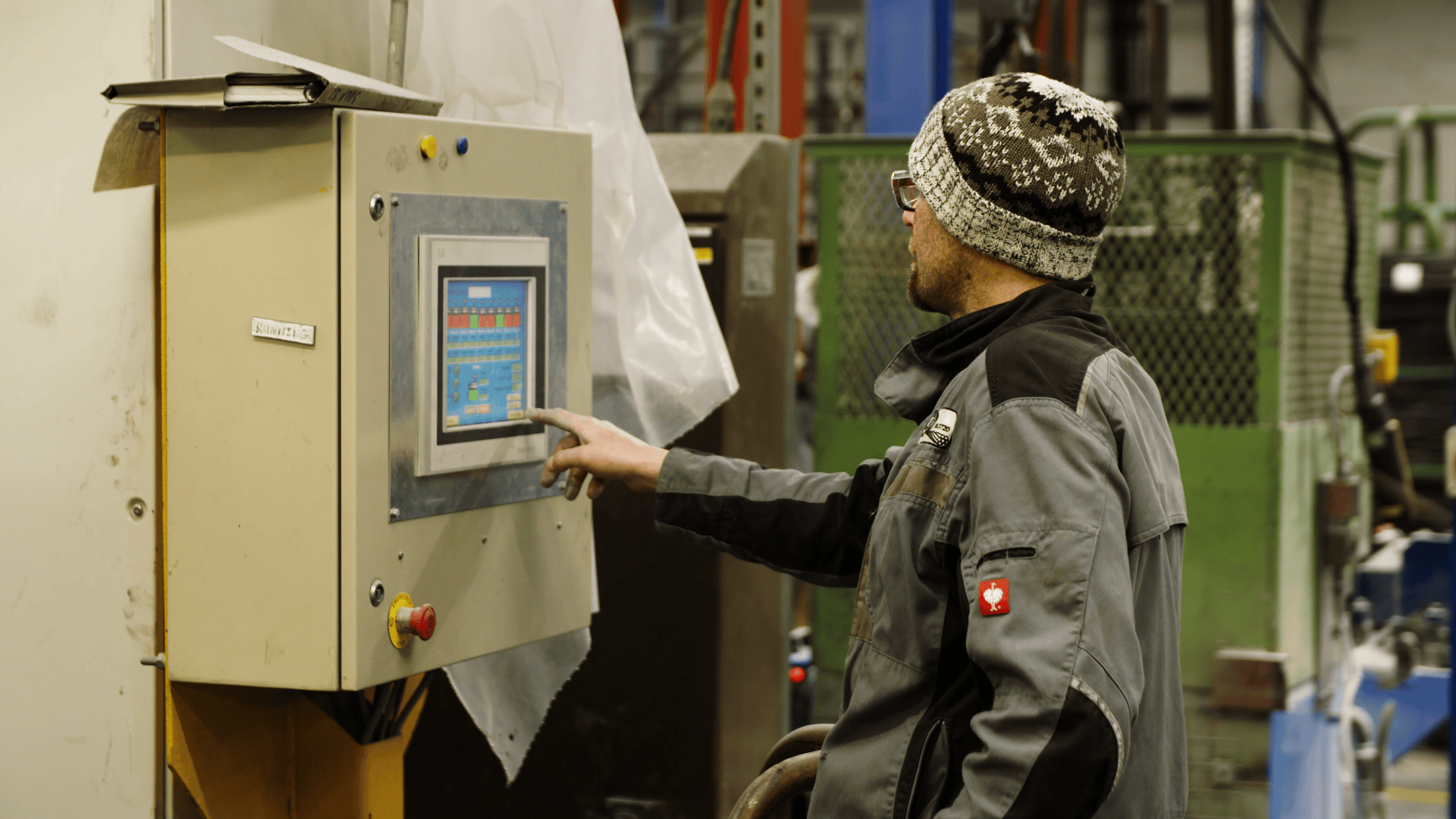 Worker operating control panel in eco-friendly manufacturing facility.