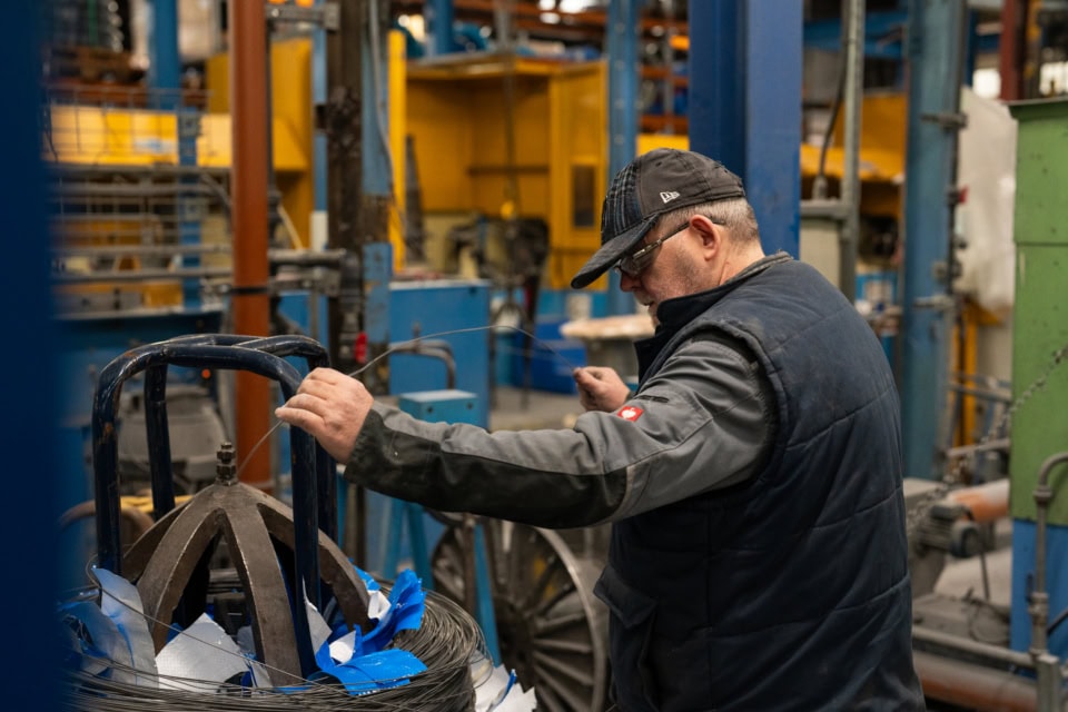 Worker inspecting machinery to lower emissions and improve sustainability.